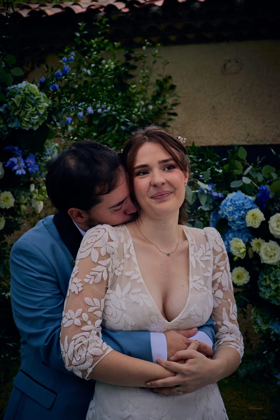 La mariée serrée dans les bras du marié, émue