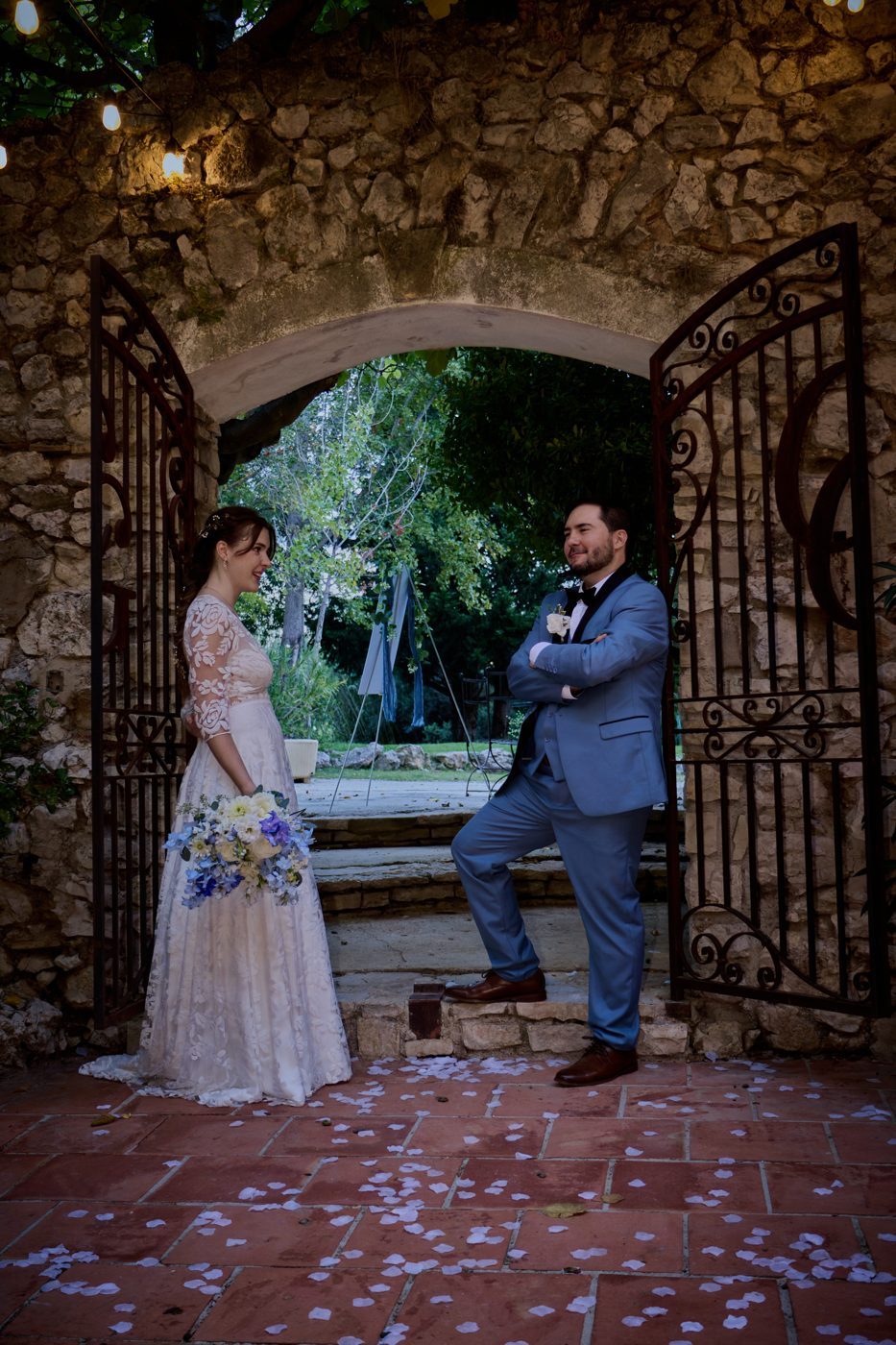 Le couple sous une voûte en pierre et un portail en fer forgé