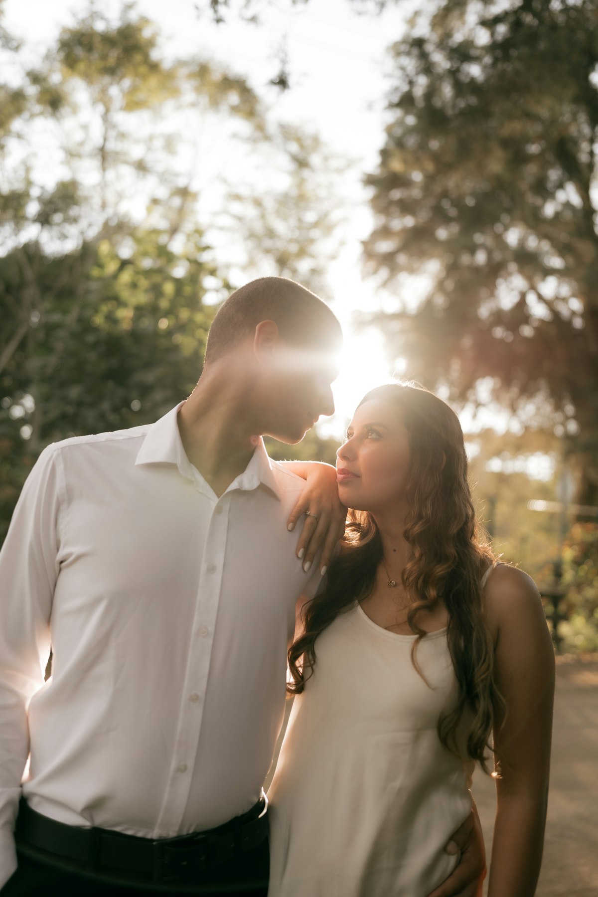 Couple enlacé en contre-jour dans un parc